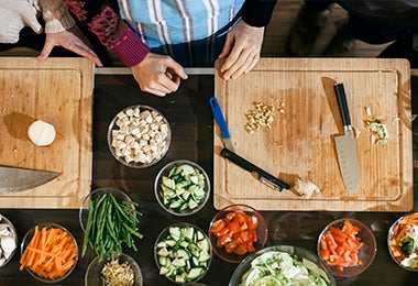 Tabla de corte con ingredientes cortados para hacer sofrito 