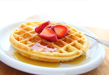 Waffle con miel y fresas al desayuno