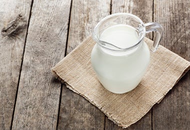 Una jarra de vidrio con leche para preparar yogurt casero