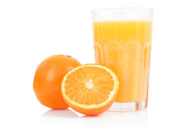 Dos naranjas y un jugo de naranja, una de las frutas con más vitaminas y nutrientes.