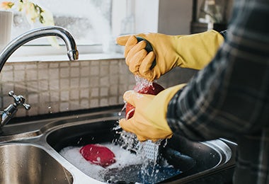 Persona escurriendo esponja. Desinfección esponjas de cocina