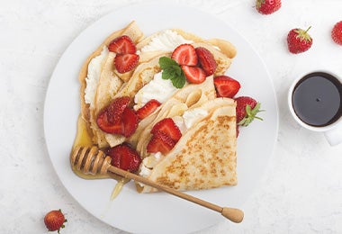  Waffle con fresas, crema, miel y hierbabuena, una comida con calorías que puedes consumir.